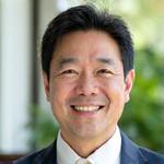 田中洋介講師の笑顔の写真。プロフェッショナルな印象。